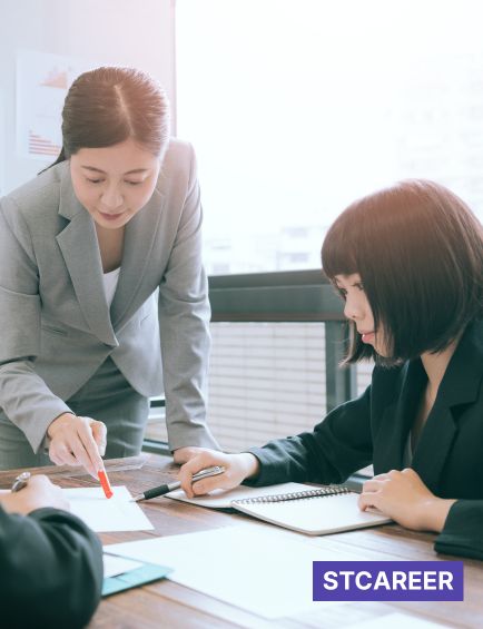 先輩社員が後輩社員に資料を使いながらアドバイスしている
